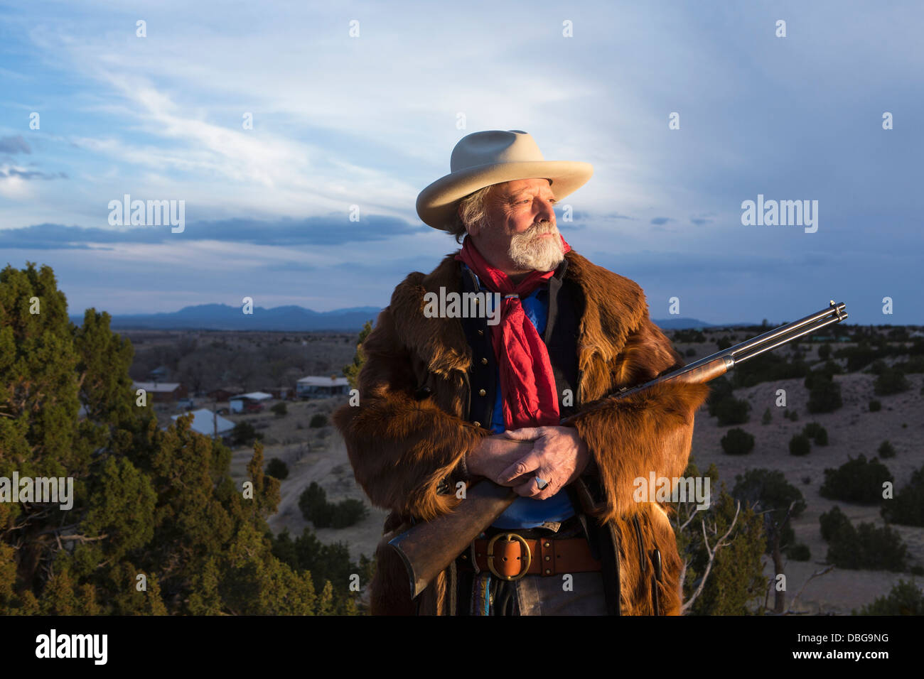 Caucasian man holding gun dans paysage poussiéreux Banque D'Images