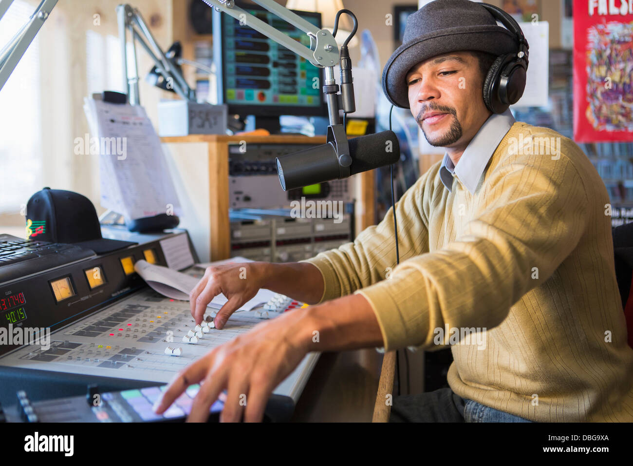 Mixed Race disc jockey l'aide de panneau en studio Banque D'Images