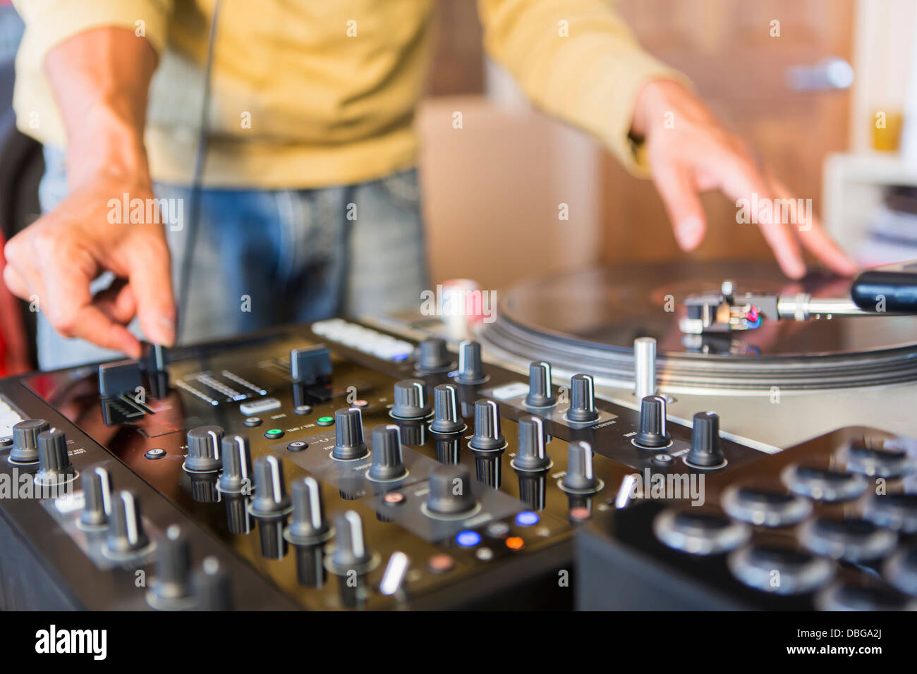 Mixed Race disc-jockey à l'aide de studio en platine Banque D'Images