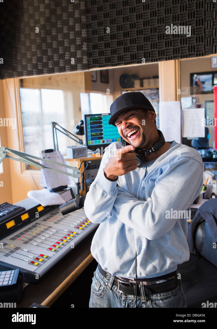 Mixed Race disc jockey smiling in studio Banque D'Images