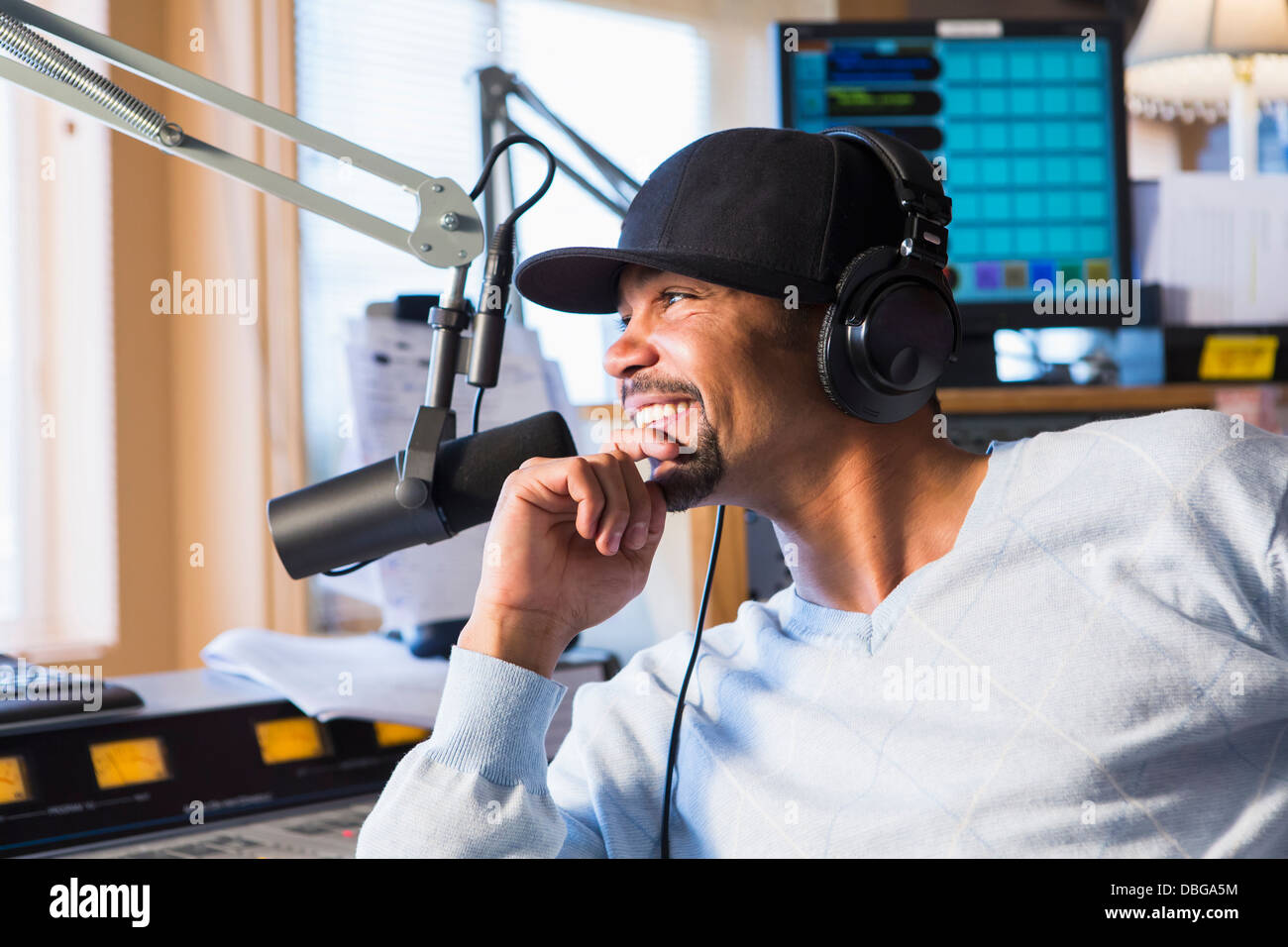 Mixed Race disc jockey smiling in studio Banque D'Images