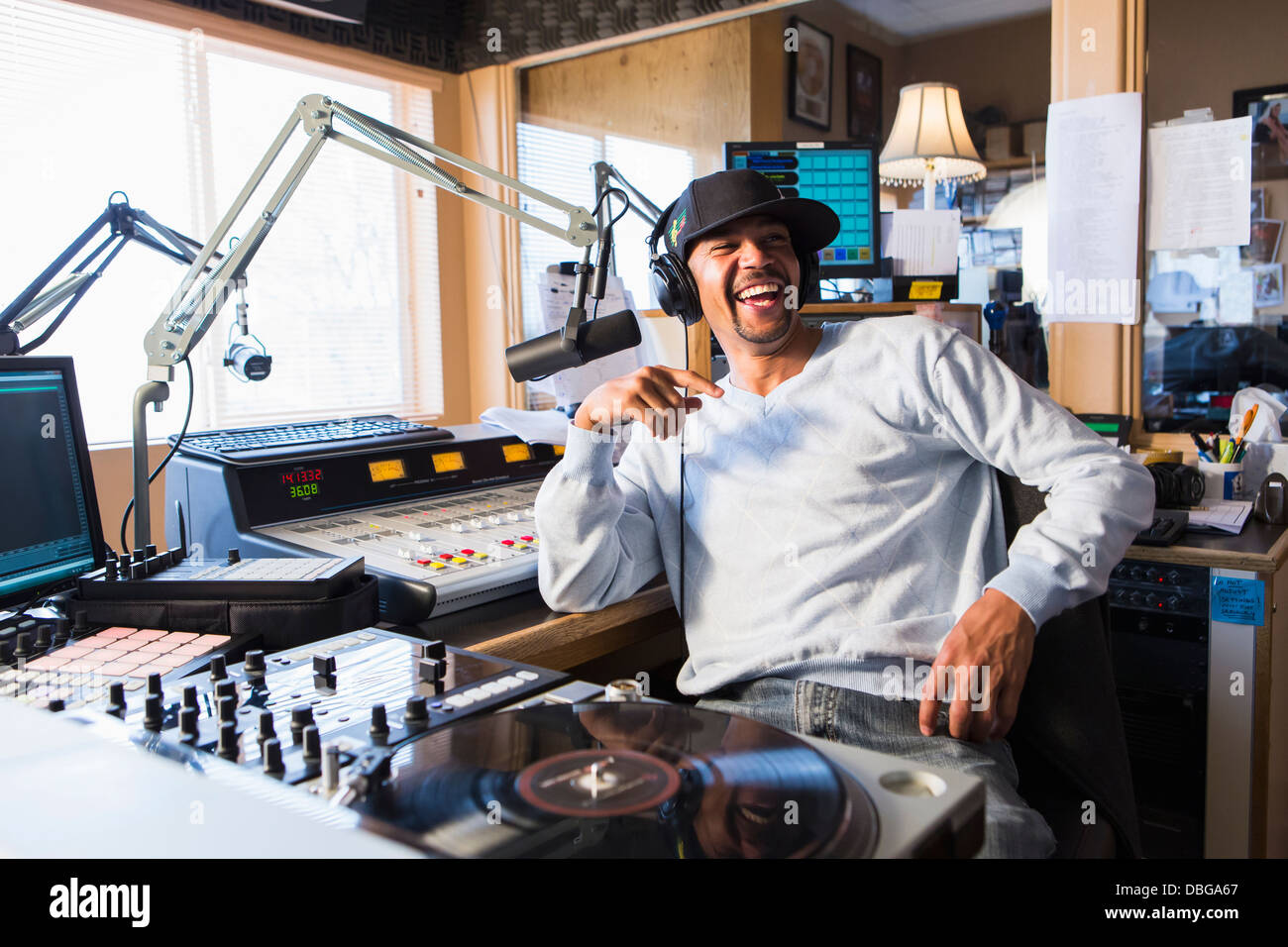Mixed Race disc jockey smiling in studio Banque D'Images