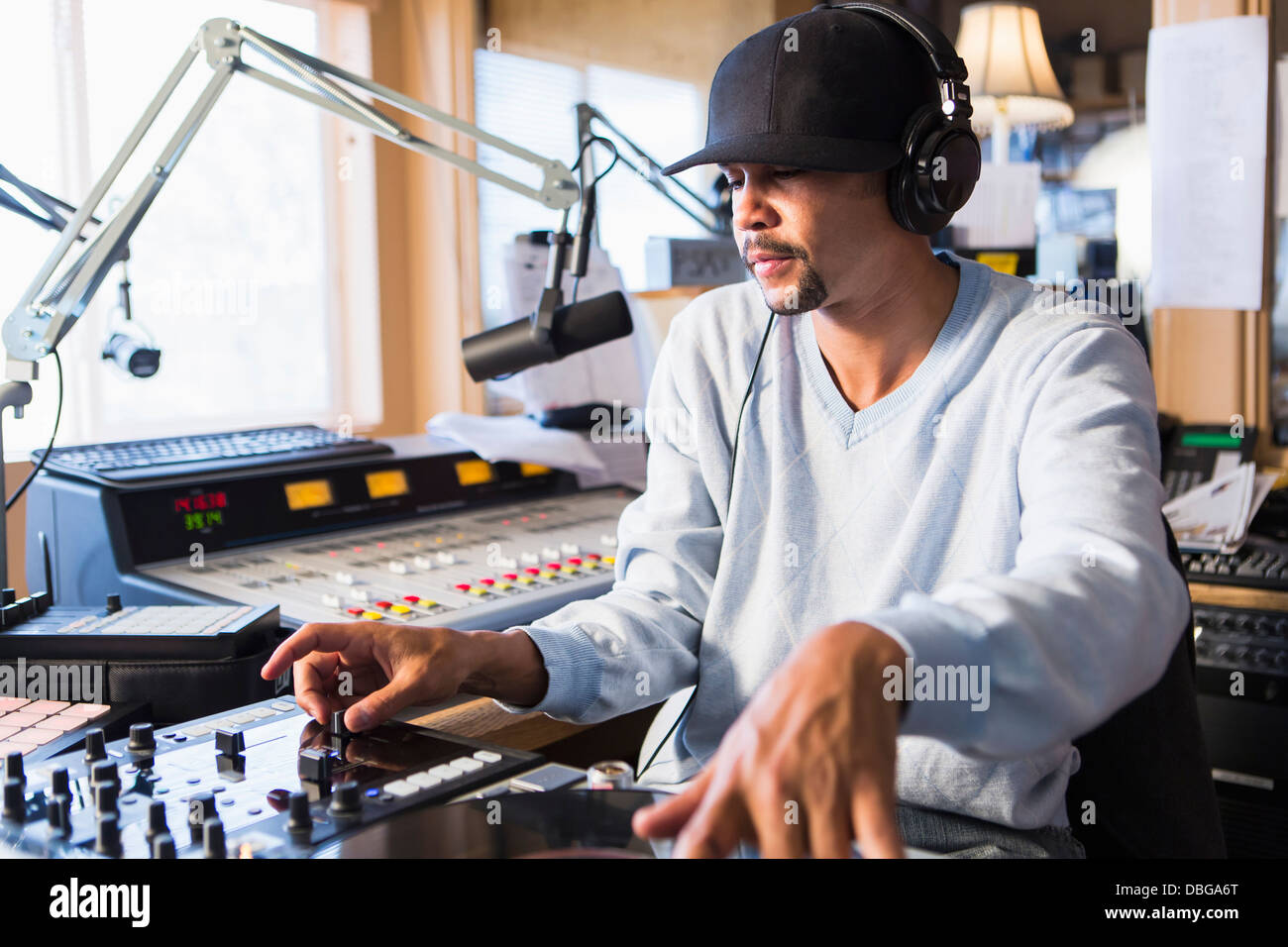 Mixed Race disc-jockey à l'aide de studio en platine Banque D'Images