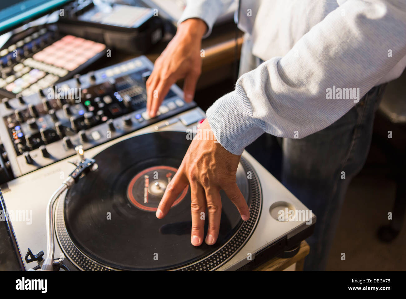 Mixed Race disc-jockey à l'aide de studio en platine Banque D'Images