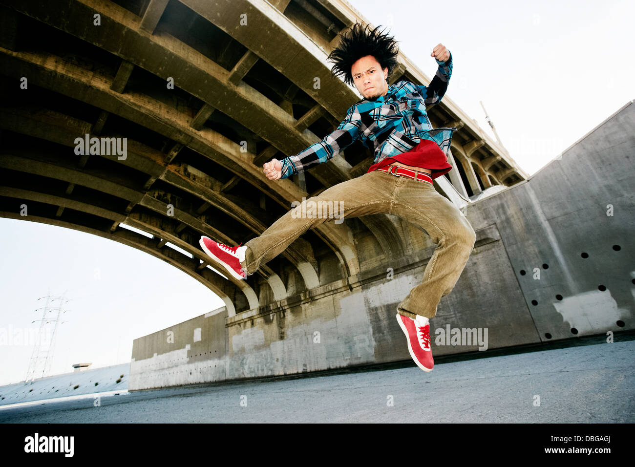 Asian man break dancing sous viaduc Banque D'Images