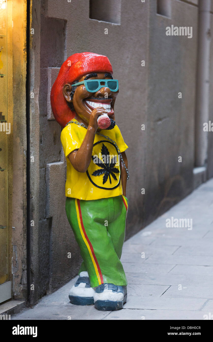 La figure d'un Rasta fumer un joint dans une ruelle dans le Barri Gòtic, Barcelone, Espagne Banque D'Images