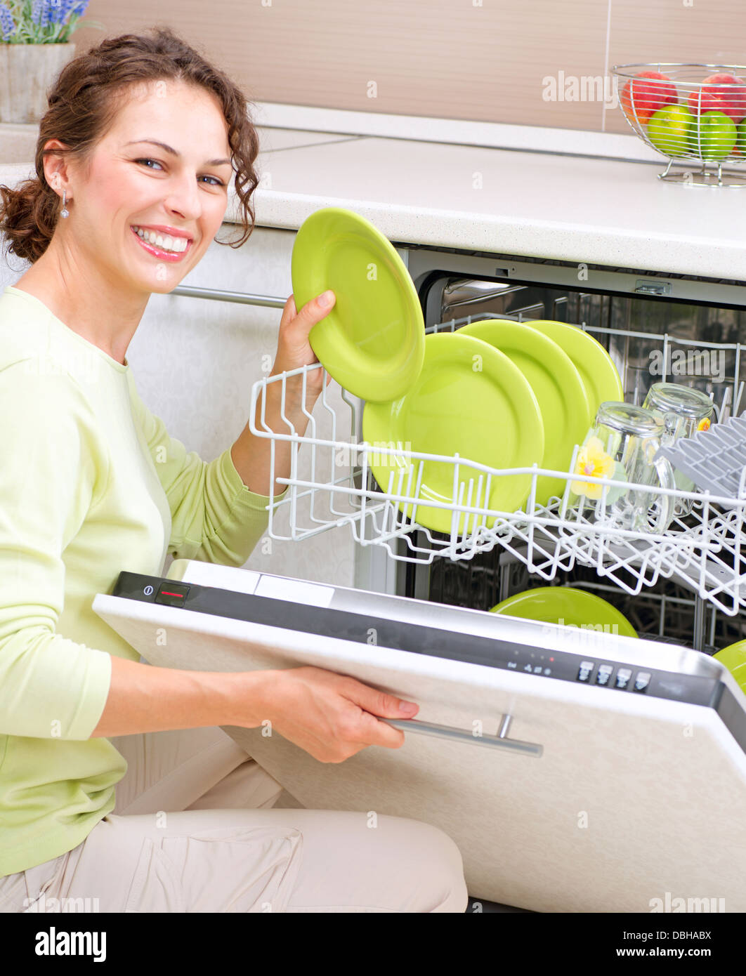 Un lave-vaisselle. Jeune femme dans la cuisine à faire des travaux ménagers. Le lavage Banque D'Images