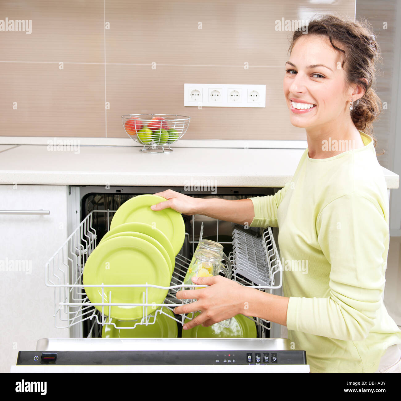 Un lave-vaisselle. Jeune femme dans la cuisine à faire des travaux ménagers. Le lavage Banque D'Images