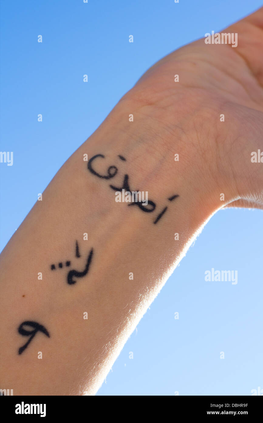 Bras avec un tatouage dans l'arabe écrit disant Asata, je crois Banque D'Images