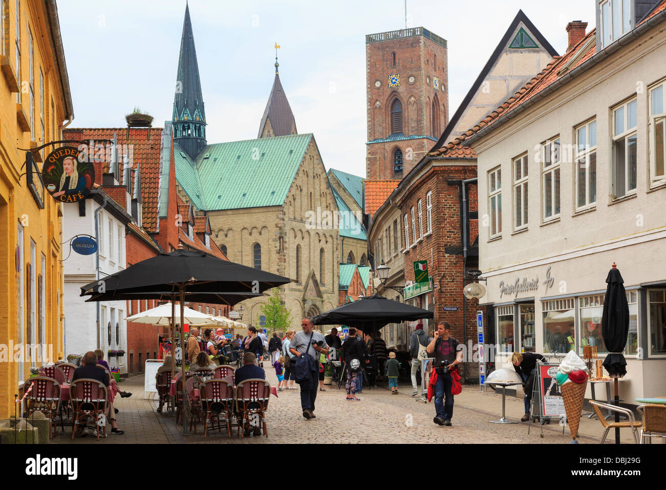 Les cafés en plein air dans la rue principale pavée piétonne en ville historique avec la Cathédrale Notre Dame Maria au-delà. Le Jutland Ribe Danemark Banque D'Images