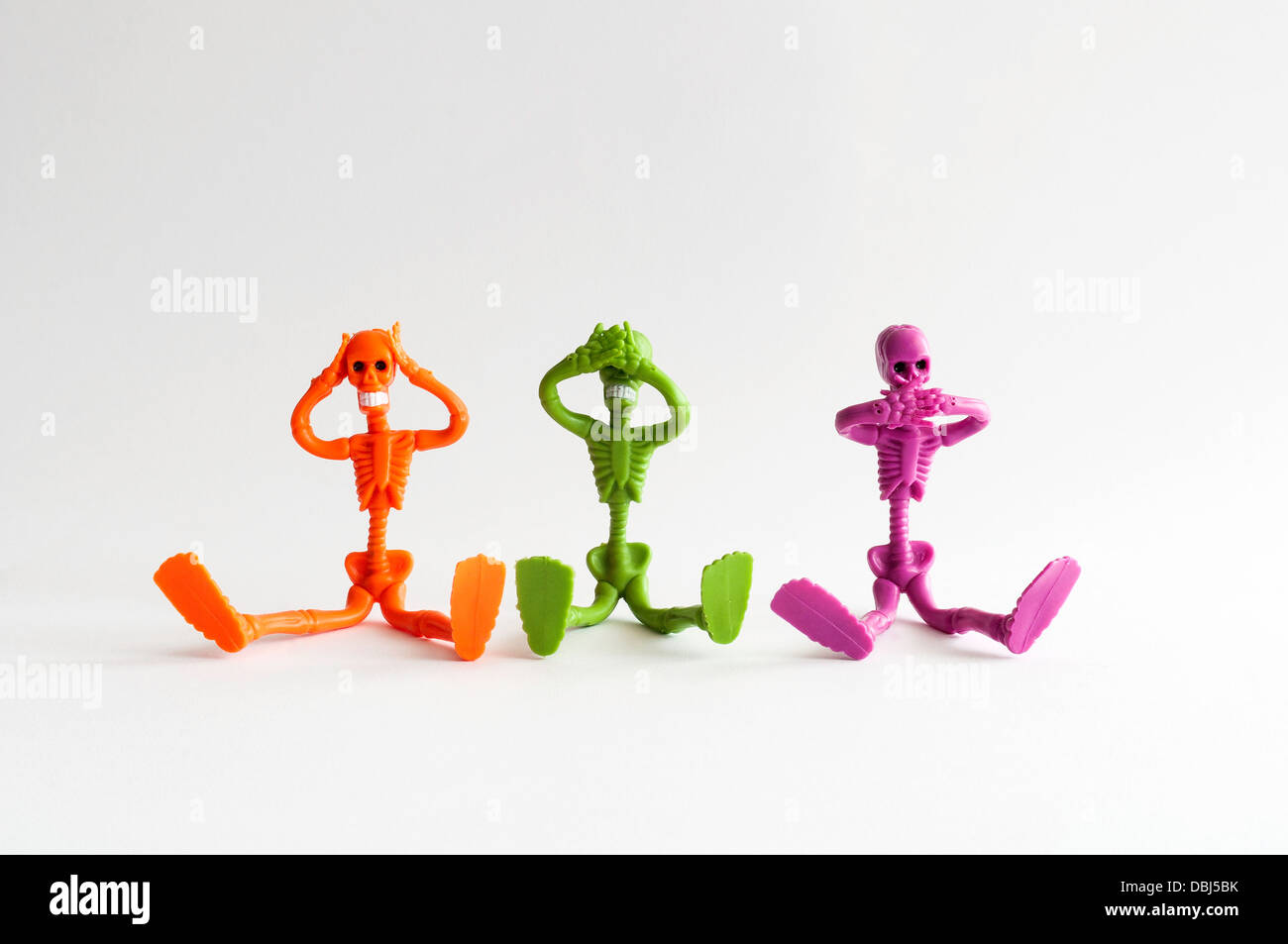 Le vert et le magenta orange trois squelettes prétendant trois singes sages Banque D'Images