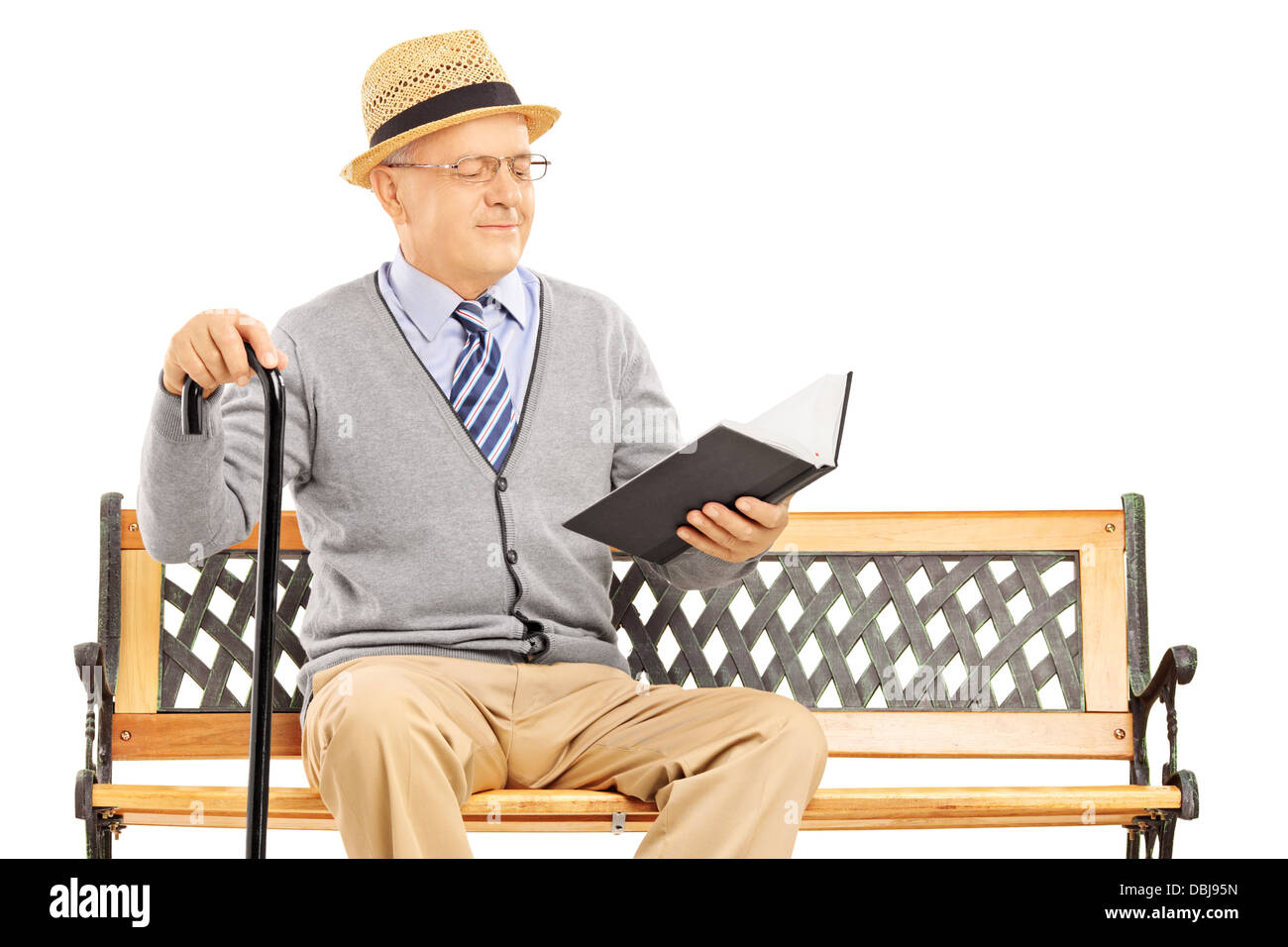 Hauts homme assis sur un banc en bois et la lecture d'un livre isolé sur fond blanc Banque D'Images