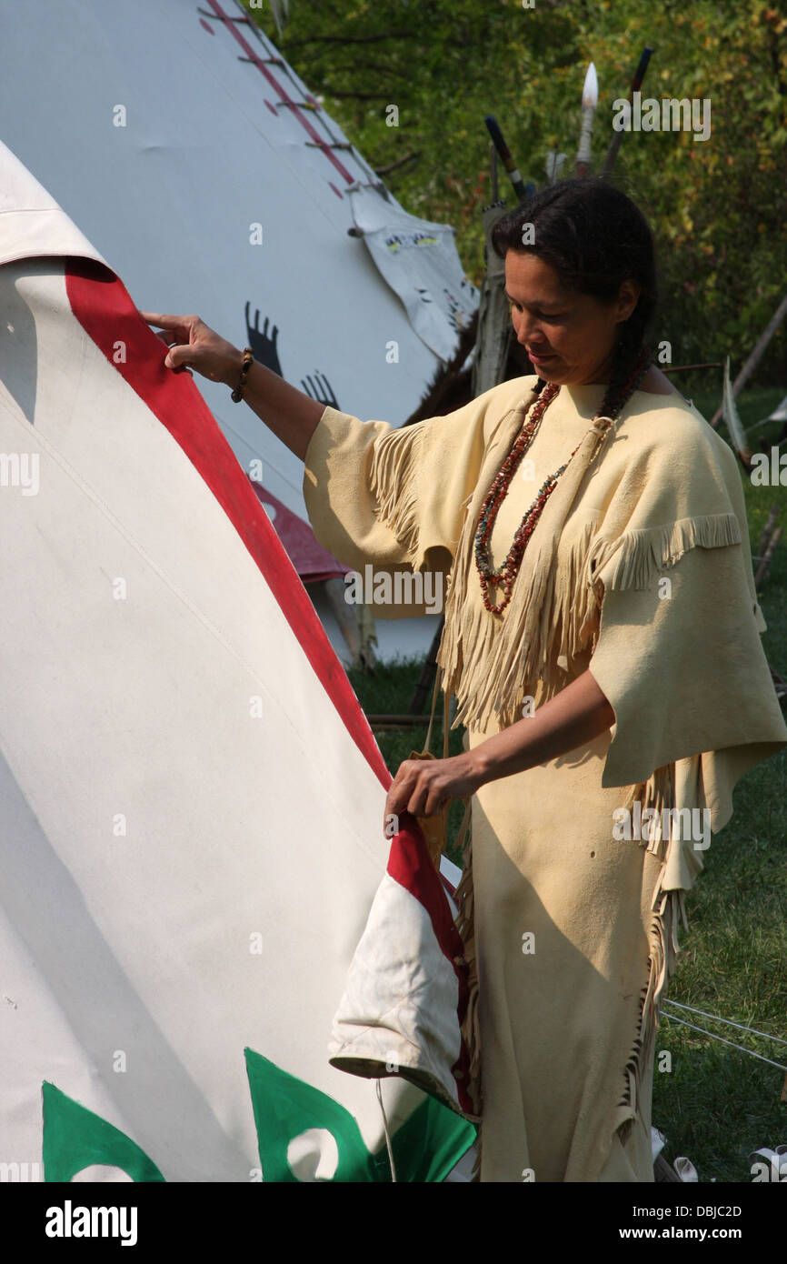 Native American Indien Lakota woman tente d'autre d'un tipi Banque D'Images