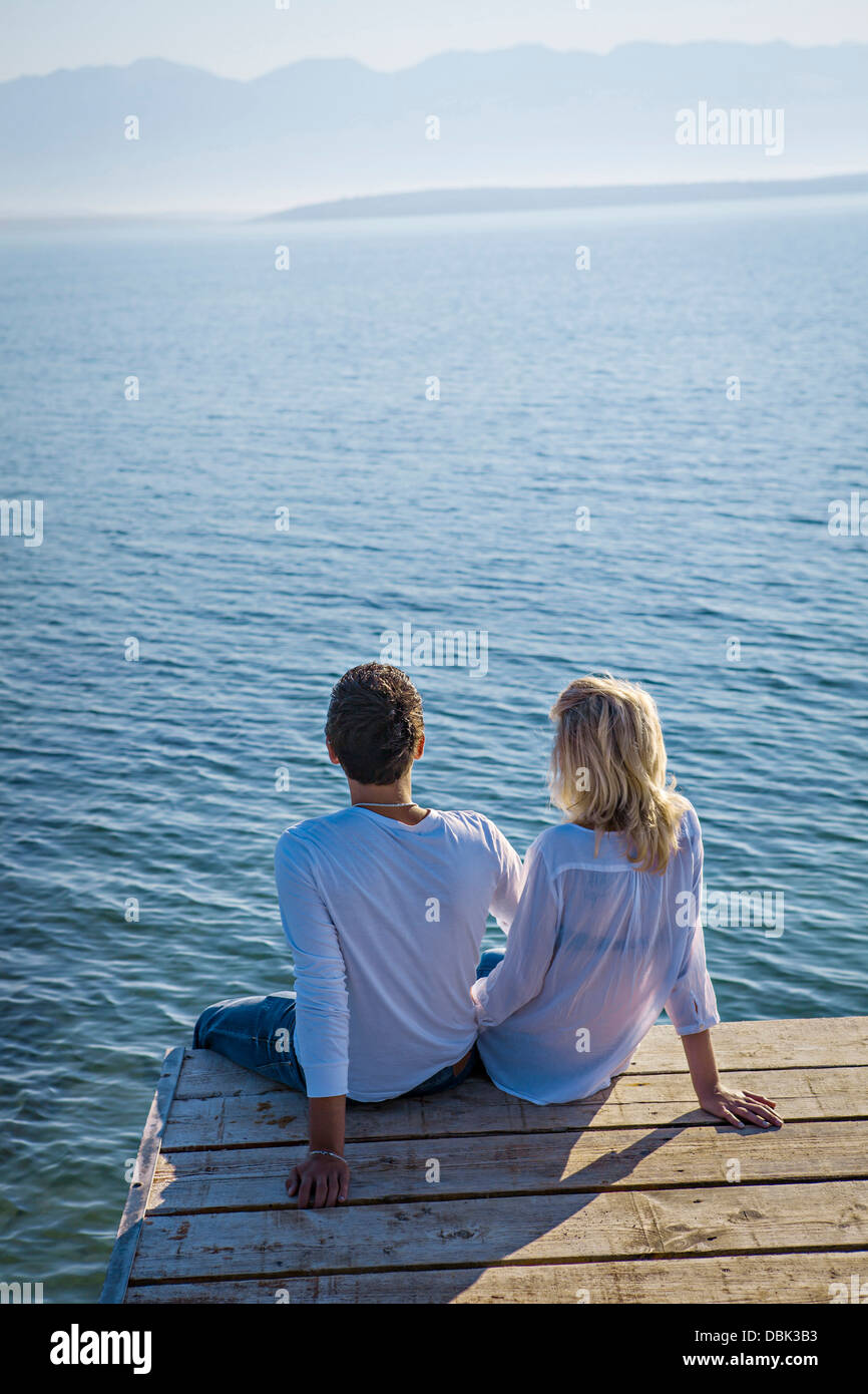 La Croatie, jeune couple se trouve sur la promenade, vue arrière, par la mer Banque D'Images