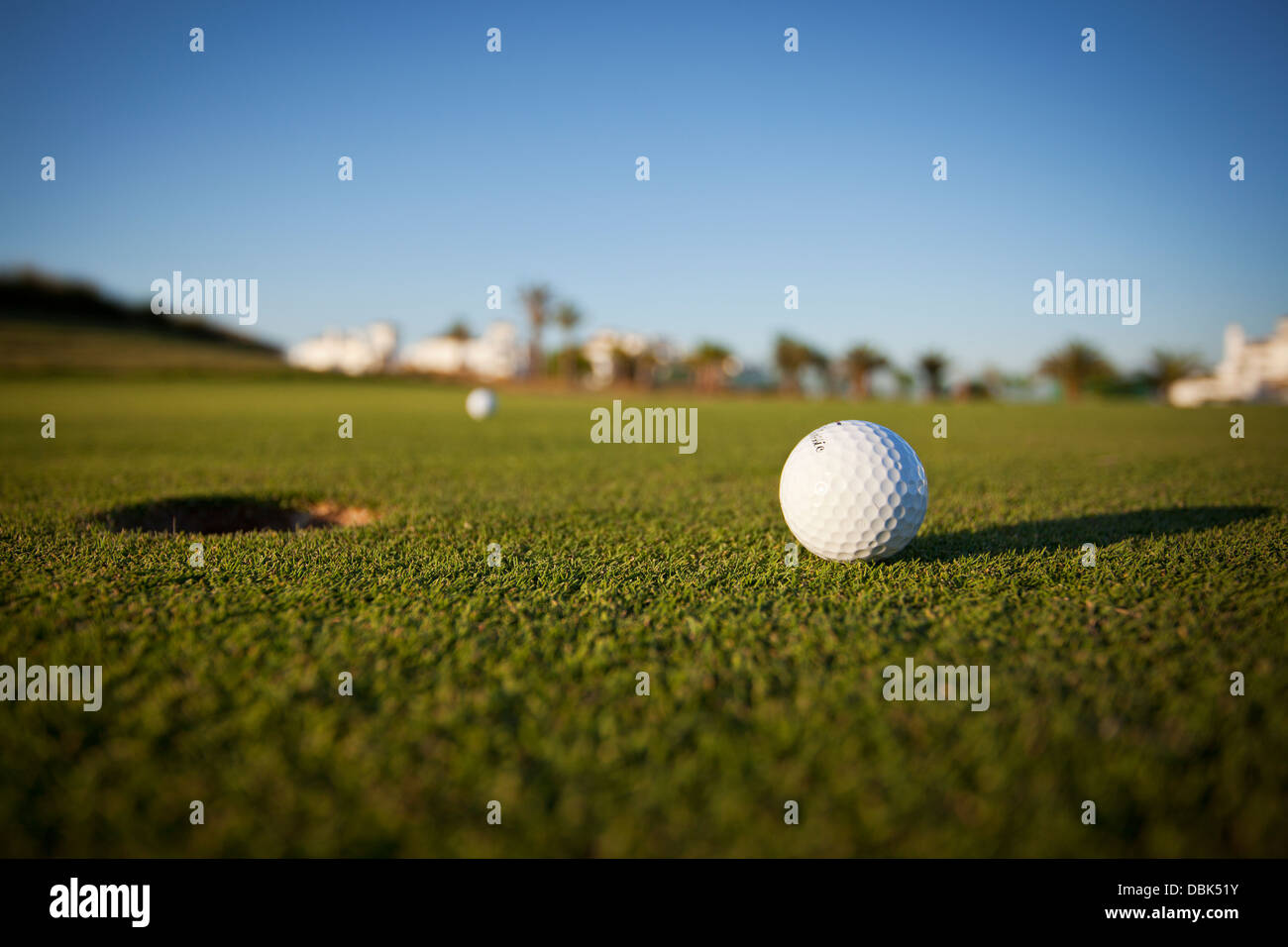 Balle de golf sur le green à côté de l'orifice Banque D'Images