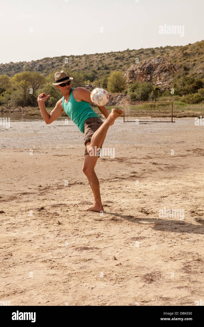 La Croatie, jeune homme sur la plage à jouer au soccer Banque D'Images