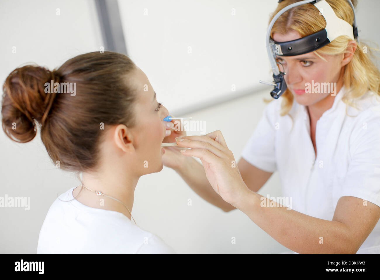 ENT médecin examine la gorge d'une patiente Banque D'Images