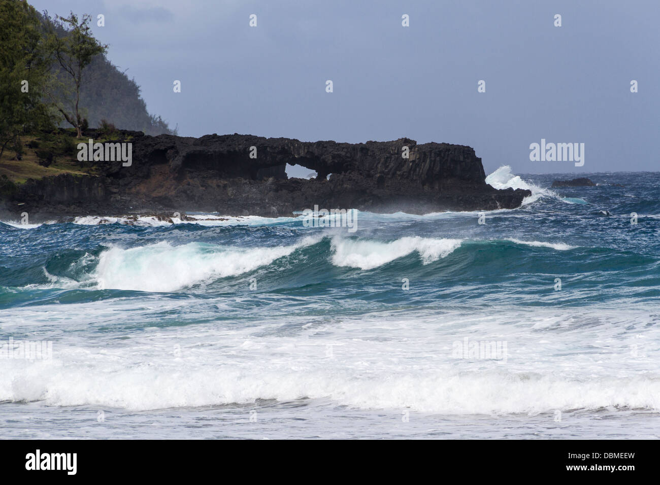 Arches et vagues qui s'écrasant sur la plage de sable rouge de Kaihalulu, à Maui, à Hawaï. Banque D'Images