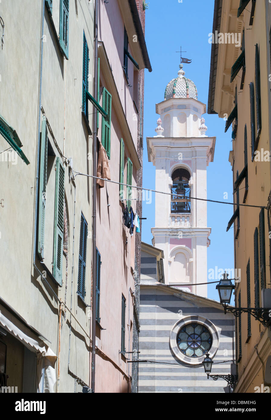 Clocher de l'église St Maria vu le long d'une rue étroite dans le nord de l'historique ville italienne d'Albenga. Banque D'Images
