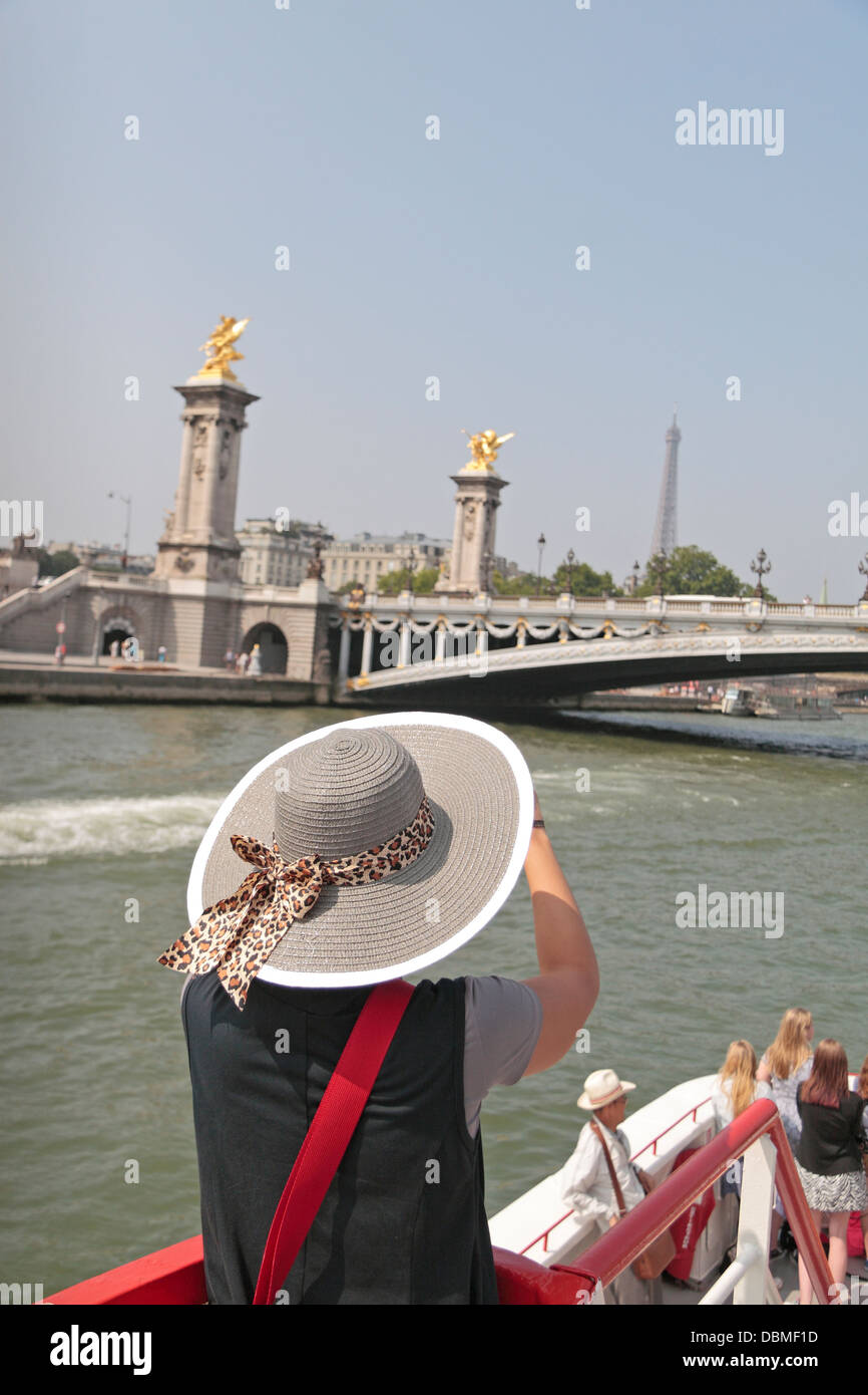 Femme avec grand chapeau sur un bateau croisière sur la Seine admire la vue  sur la Tour Eiffel à Paris, France Photo Stock - Alamy