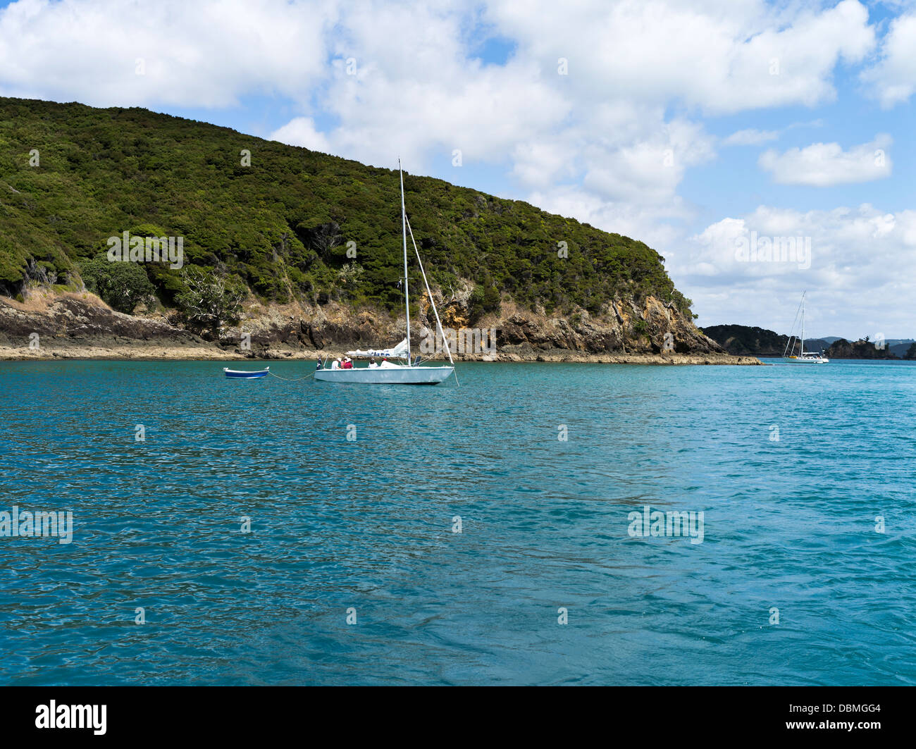 Dh BAIE DES ÎLES NOUVELLE ZELANDE Rocky coast islands yacht à voile et canot nz Banque D'Images