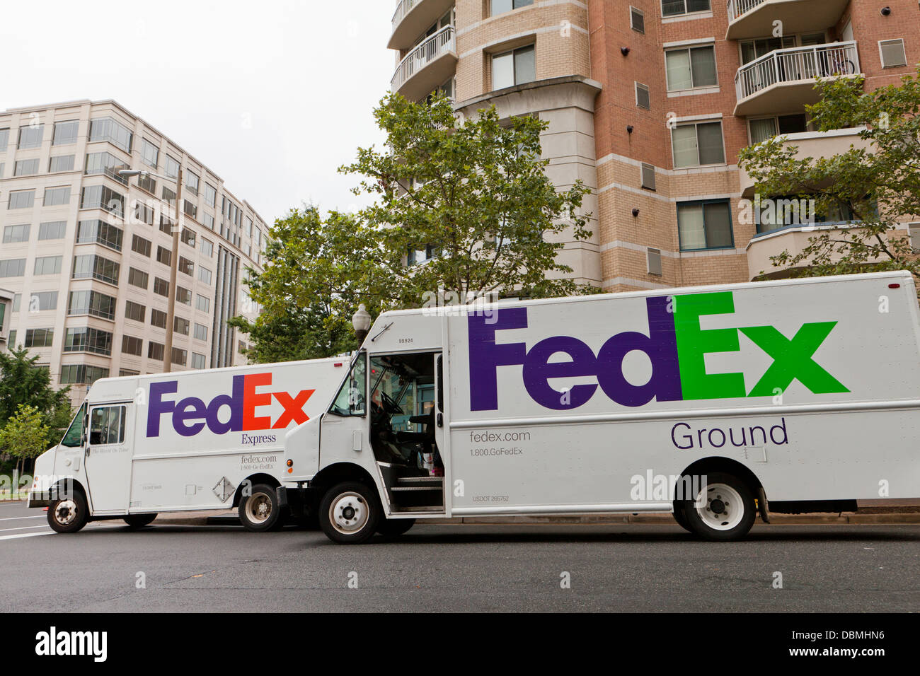 Les camions de livraison FedEx garée en face de l'appartement immeuble Banque D'Images