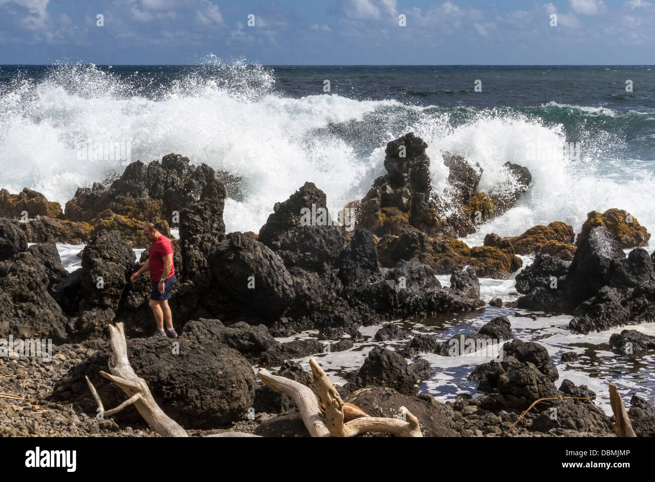Touriste sur la plage et les vagues de l'océan à la péninsule de Keanae, le long de la route vers Hana sur Maui à Hawaï. Banque D'Images