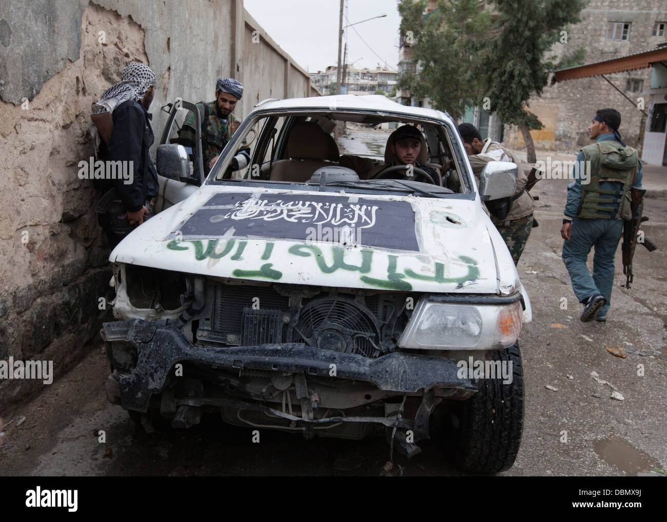 Les membres de l'Armée syrienne libre montent dans une voiture avant et l'exploitation à Alep, Syrie :. Banque D'Images