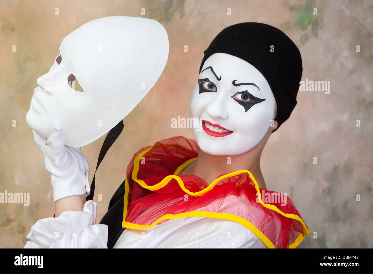 Femme tenant un pierrot souriant masque blanc grave Banque D'Images