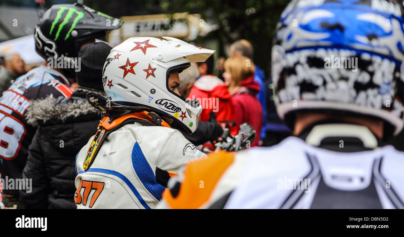 Les coureurs de motocross avec des casques et tous les rapports prêts avant le début de la course. 3 cavaliers sur les photos entouré de personnes Banque D'Images