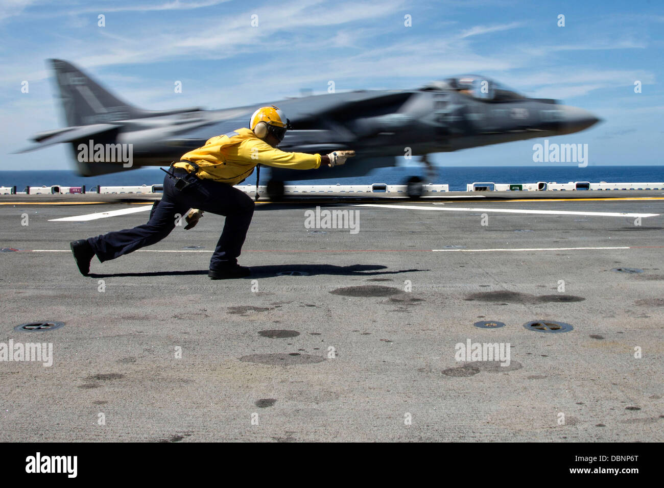 L'Aviation de l'US Navy un manoeuvrier Mate signale un Harrier AV-8B II fighter jet pour lancer sur le poste de pilotage de l'assaut amphibie USS Wasp 27 juillet 2013 opérant dans l'océan Atlantique. Banque D'Images