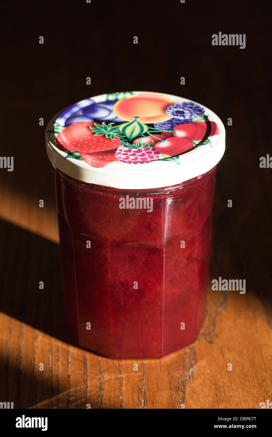 Un pot de confiture de prune quetsche fraîchement préparés sur une table en bois. Banque D'Images