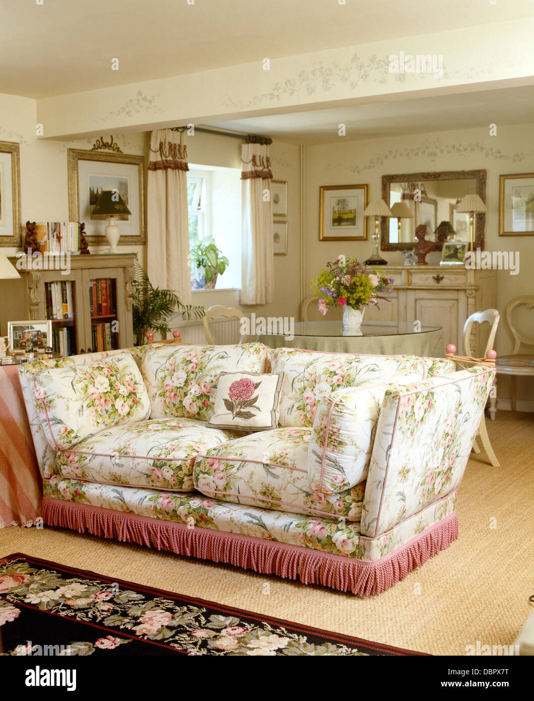 Canapé floral rose avec bordure frangée de cottage salon et salle à manger  avec poutre au pochoir Photo Stock - Alamy