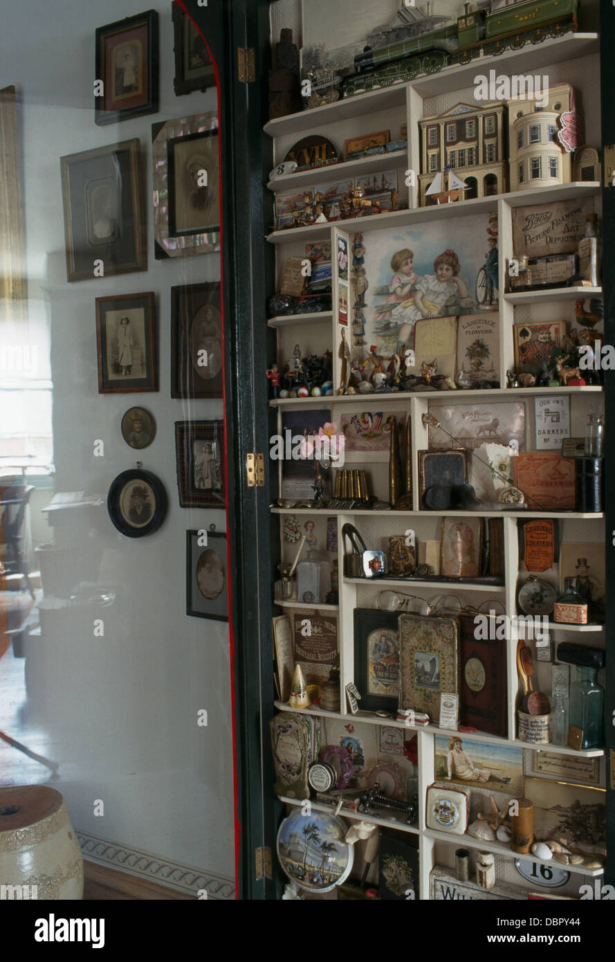 Close-up de la collection de jouets anciens et des documents éphémères sur des étagères dans une armoire avec porte en verre Banque D'Images