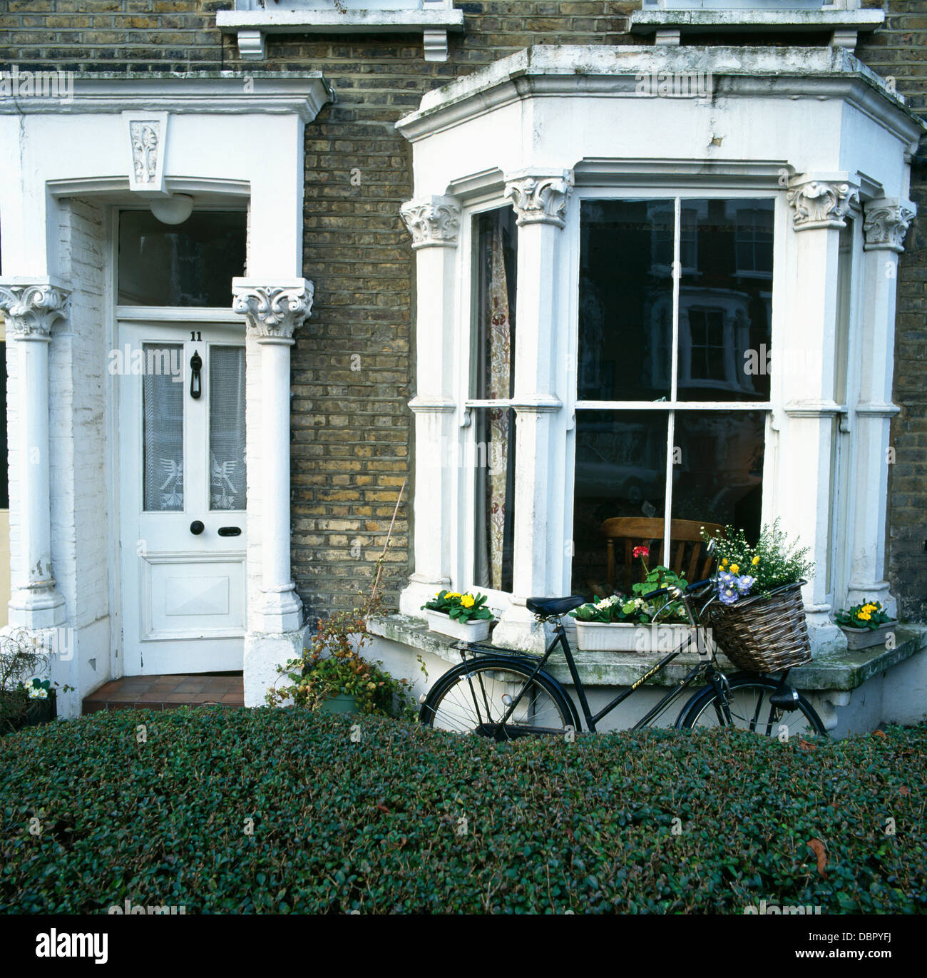 Couverture agrafée en face de Victorian maison jumelée avec un vieux vélo appuyé contre fenêtre en baie Banque D'Images