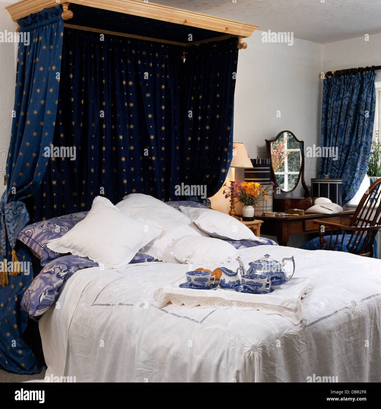 Rideaux bleu sur un lit à dais de coton blanc avec couvre-lit et  petit-déjeuner de style victorien avec bac blanc bleu +Chine Photo Stock -  Alamy