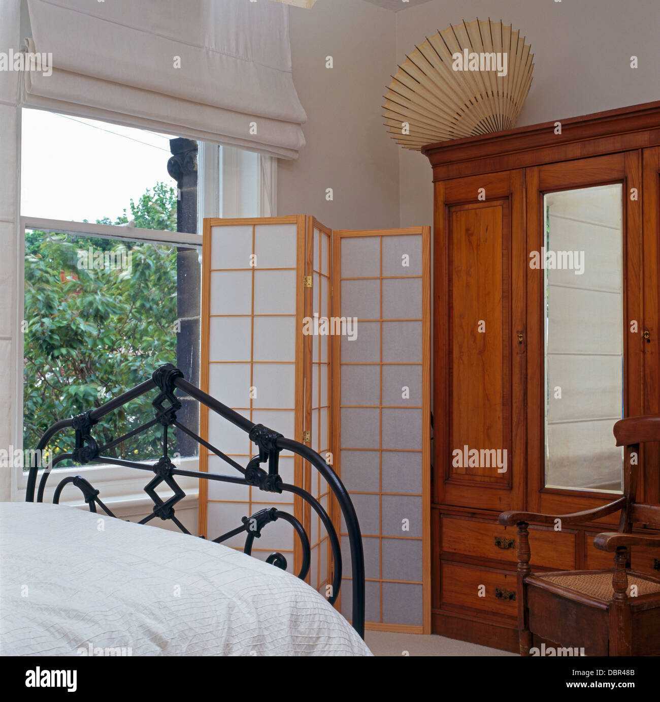 Paravent de style japonais et grand vintage armoire avec porte miroir en  blanc appartement chambres avec lit en fer forgé Photo Stock - Alamy