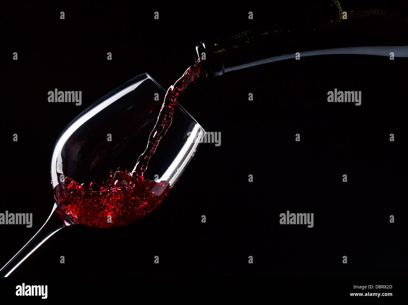 Bouteille et verre de vin rouge sur fond noir Banque D'Images