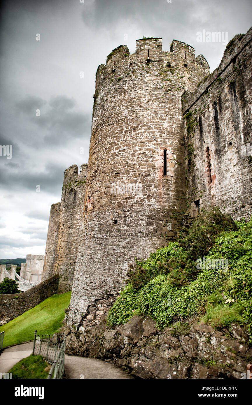 CONWY, pays de Galles — les imposantes tourelles et murs du château de Conwy s'élèvent contre un ciel nuageux dans le nord du pays de Galles. Cette forteresse médiévale du XIIIe siècle, construite entre 1283 et 1287 lors de la conquête du pays de Galles par Édouard Ier, est l'un des plus beaux exemples d'architecture militaire de la fin du XIIIe et du début du XIVe siècle en Europe. Le château fait partie de l'anneau de fer d'Édouard Ier des fortifications dans le nord du pays de Galles et a été désigné site du patrimoine mondial de l'UNESCO en 1986. Les huit tours rondes massives et les hauts murs-rideaux du château de Conwy ont été conçus par Maître James de compris George, le principal ingénieur militaire de l'époque. Banque D'Images