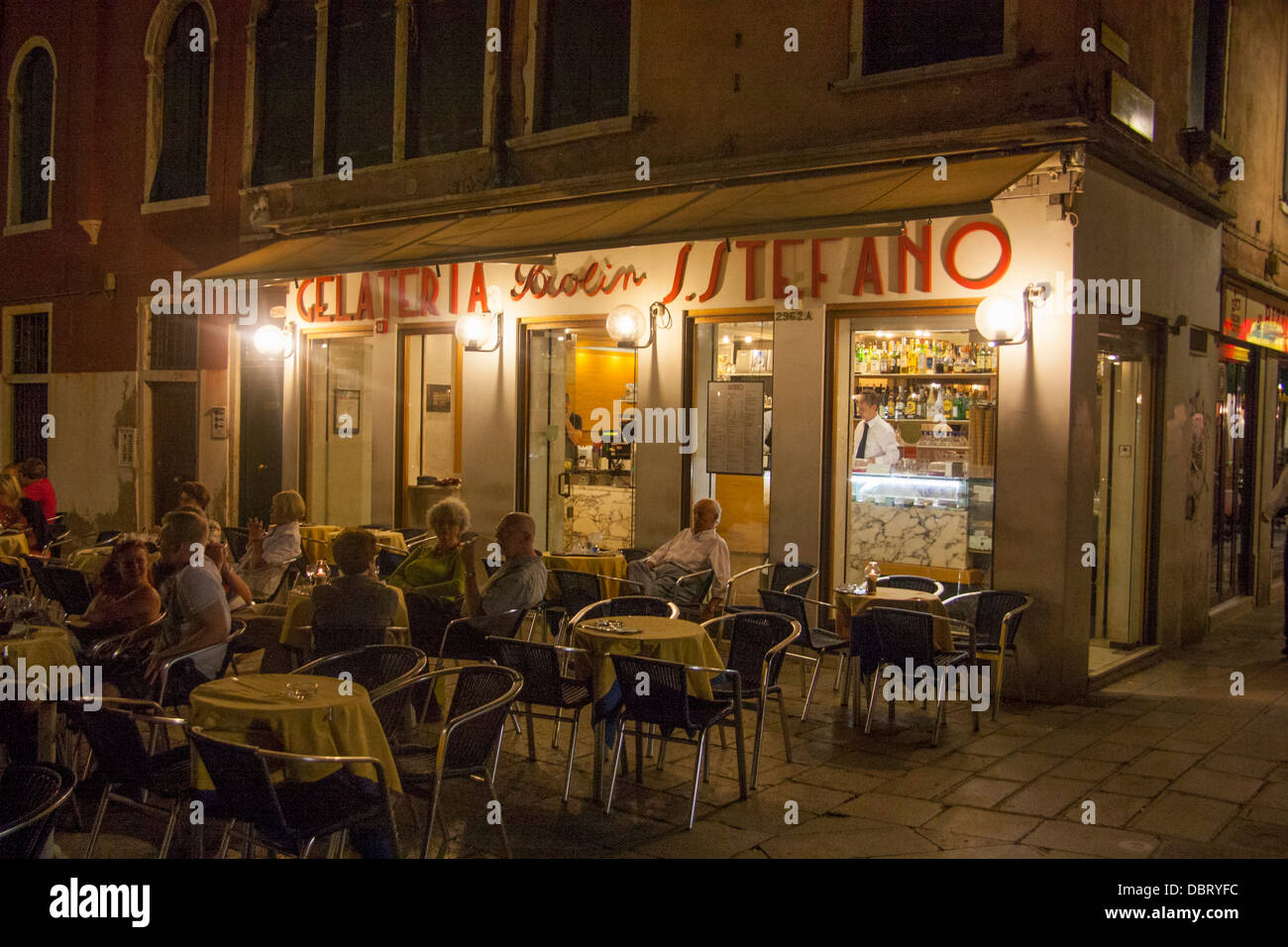 Gelateria sur Campo Santo Stefano avec des gens assis dehors la nuit en plein air sestier San Marco Venise Vénétie Italie Banque D'Images