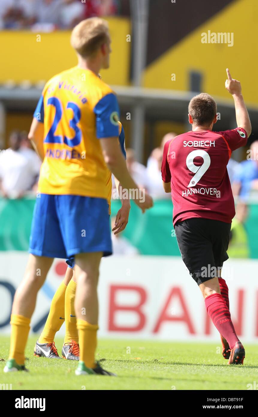 Hambourg, Allemagne. Le 04 août, 2013. Artur Sobiech Hannover (R) célèbre son but de 1-0 lors du premier tour de la coupe DFB entre SC Victoria Hambourg et Hanovre 96 au stade Hoheluft à Hambourg, Allemagne, 04 août 2013. Photo : CHRISTIAN CHARISIUS (VEUILLEZ NOTER : La DFB interdit l'utilisation et la publication d'images séquentielles sur l'internet et autres médias en ligne pendant le match (y compris la mi-temps). Période de blocage ! La DFB permet l'utilisation et la publication des photos pour les services mobiles (MMS) et en particulier pour le DVB-H et DMB seulement après la fin du match... Banque D'Images