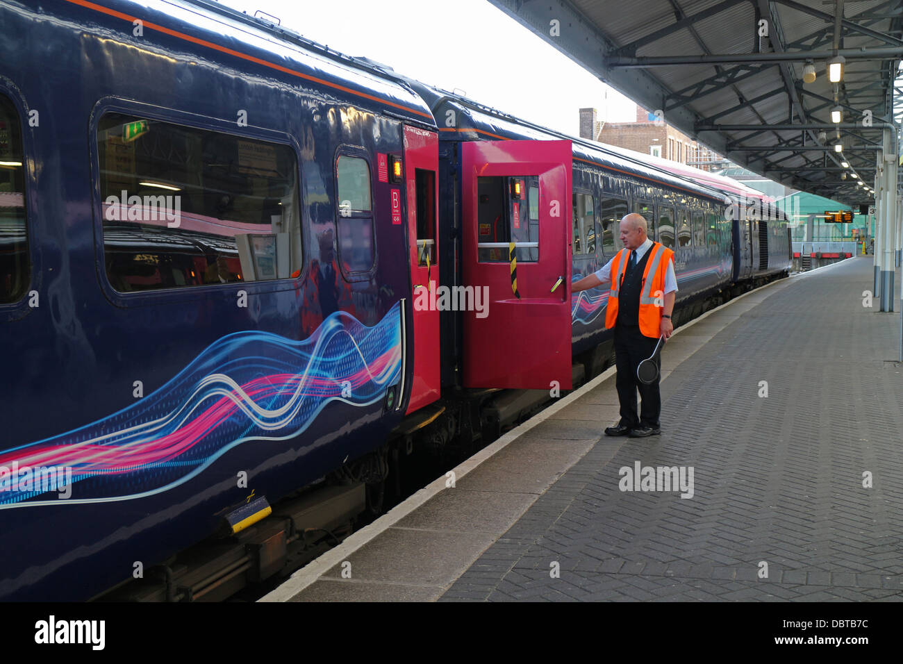 Le gestionnaire de la gare train départ de signalisation sur la plate-forme à la gare de Swansea 132016 Train Great Western Banque D'Images