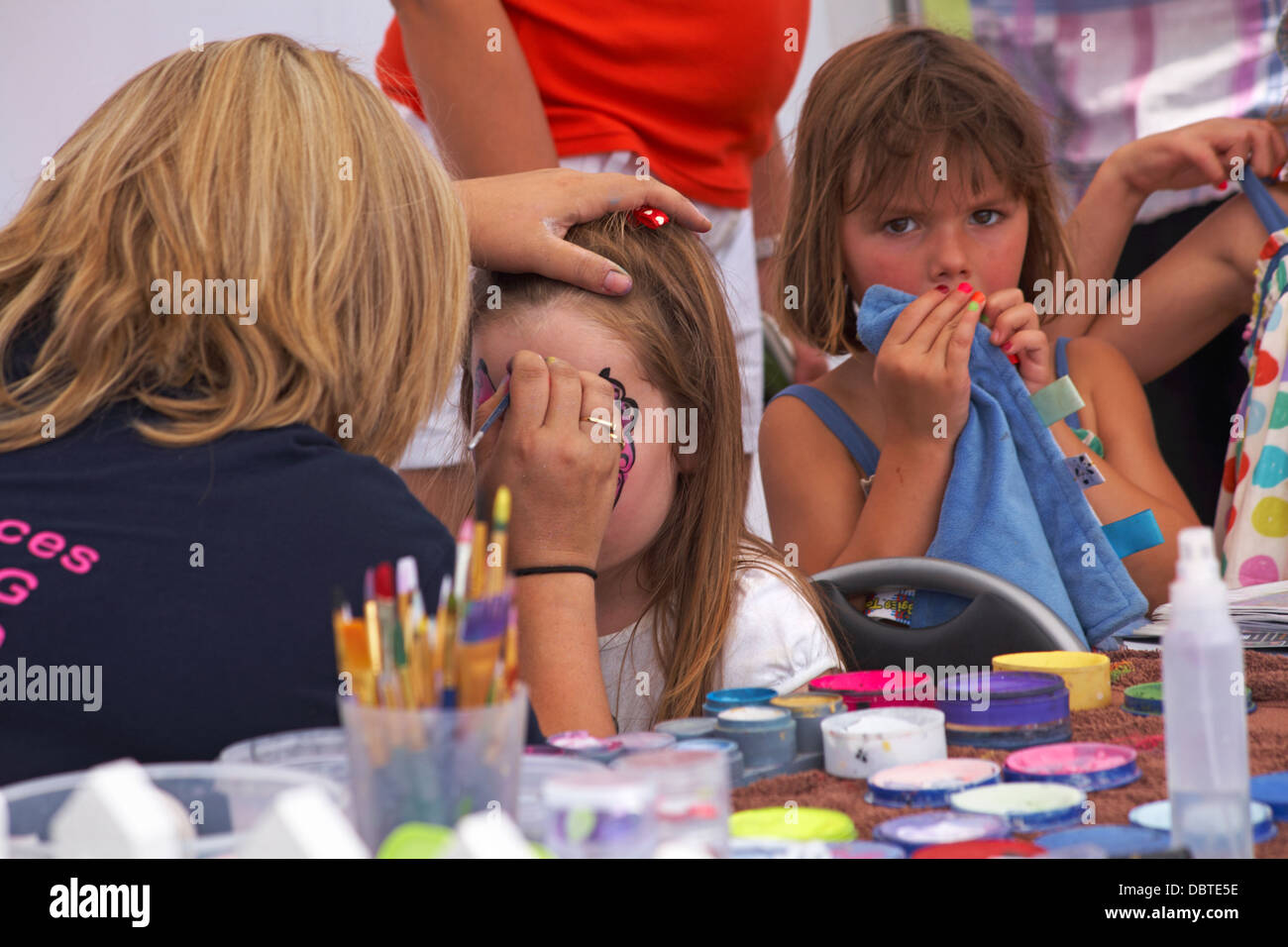 Face painting - peinture femme papillon rose sur le visage de la fille de conception Banque D'Images