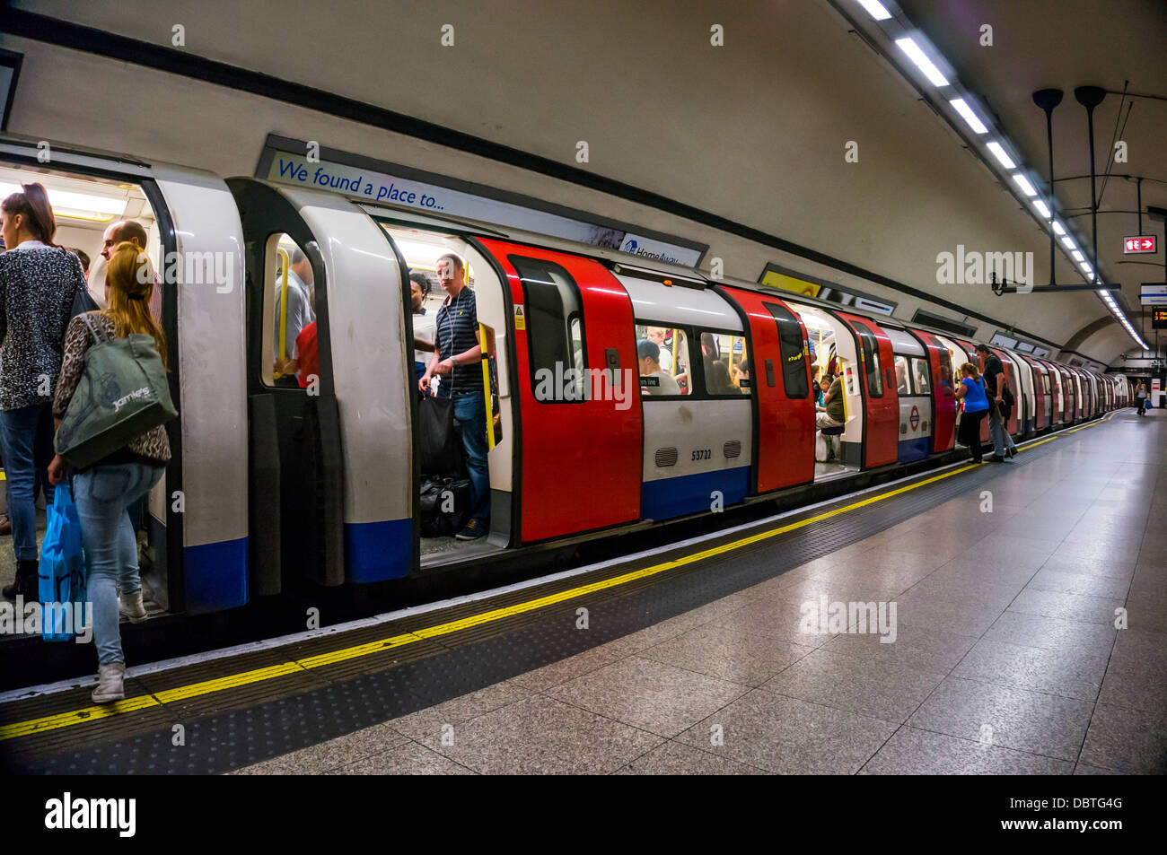 London Underground tube train - passagers / banlieusards chariots. Embarquement Plate-forme vide avec le train sur le point de quitter la station. Angleterre, Royaume-Uni. Banque D'Images