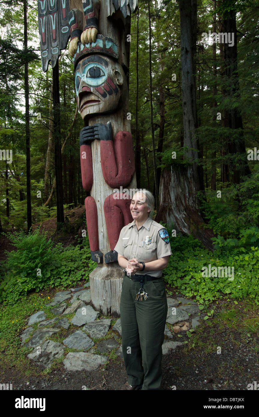 Un parc d'état de l'Alaska est ranger par un totem au parc d'état de Totem Bight près de Ketchikan, Alaska. Banque D'Images