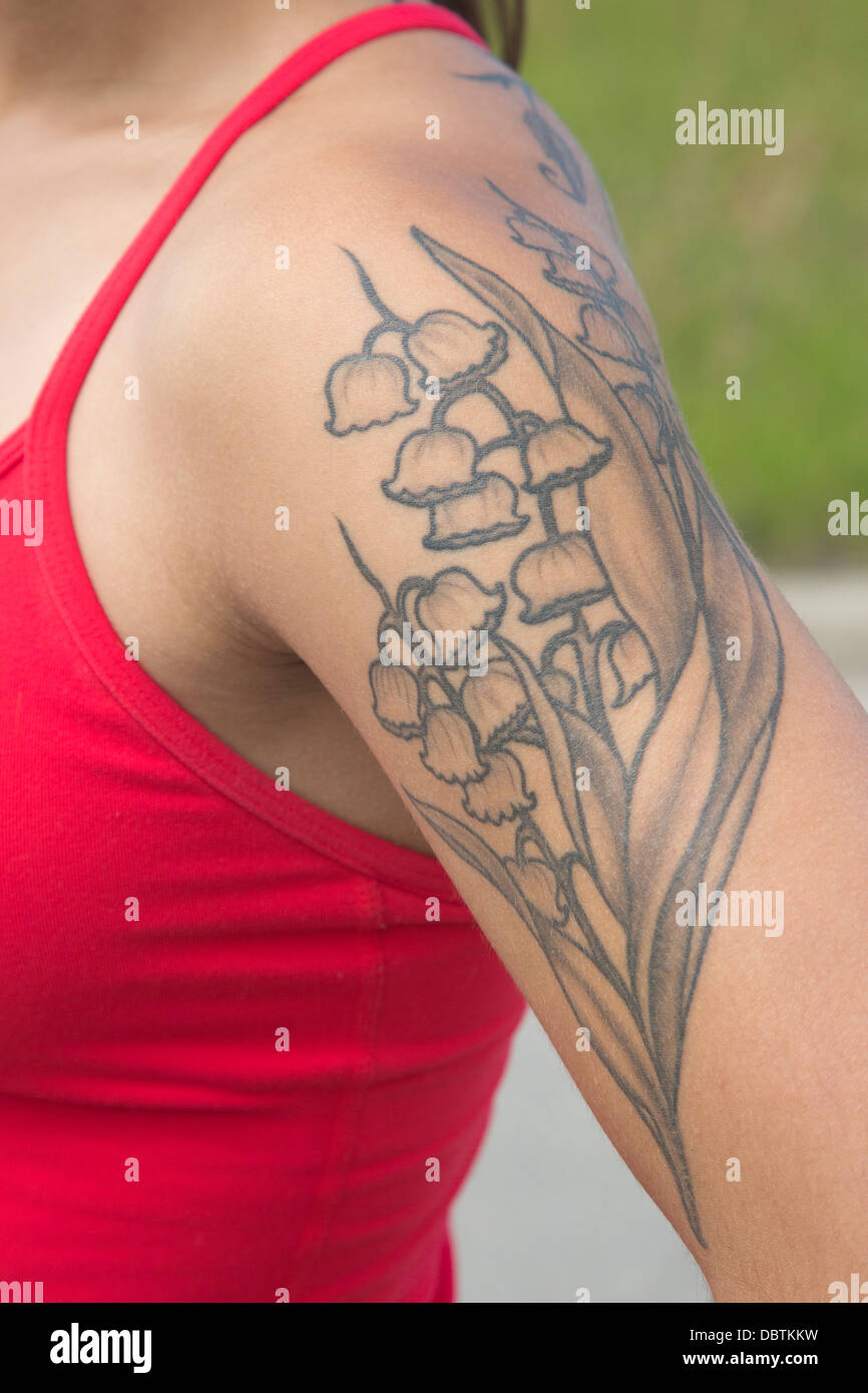 Le muguet tatouage sur le bras de la femme Banque D'Images