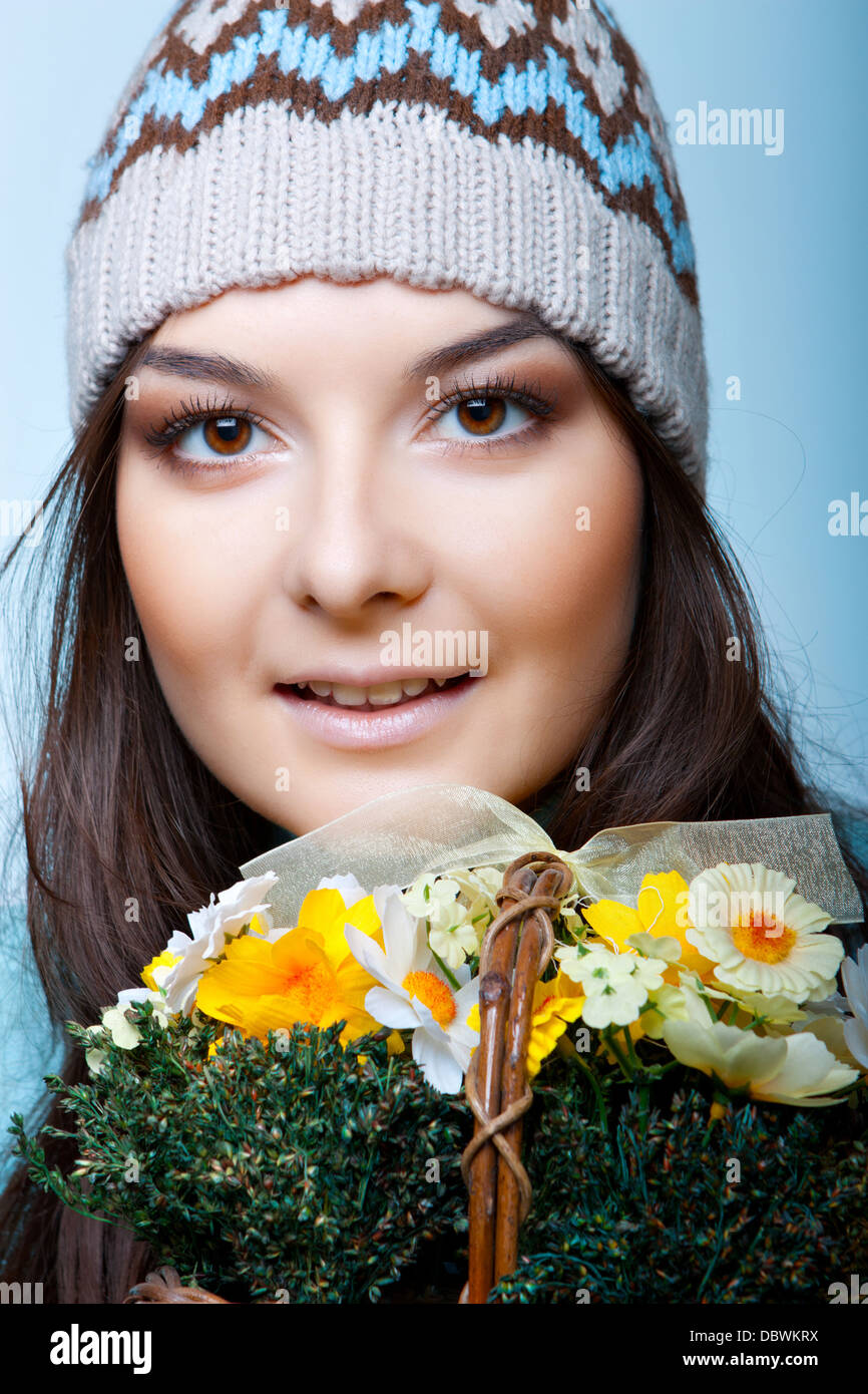 Smiling woman in cap avec panier de fleurs Banque D'Images