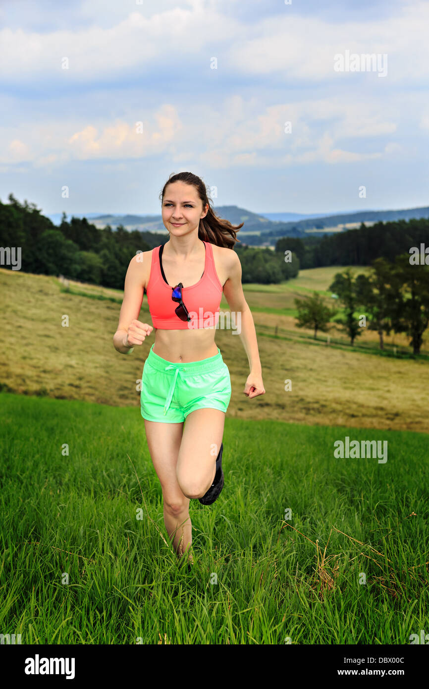 Jeune femme jogging en face de cross country Banque D'Images