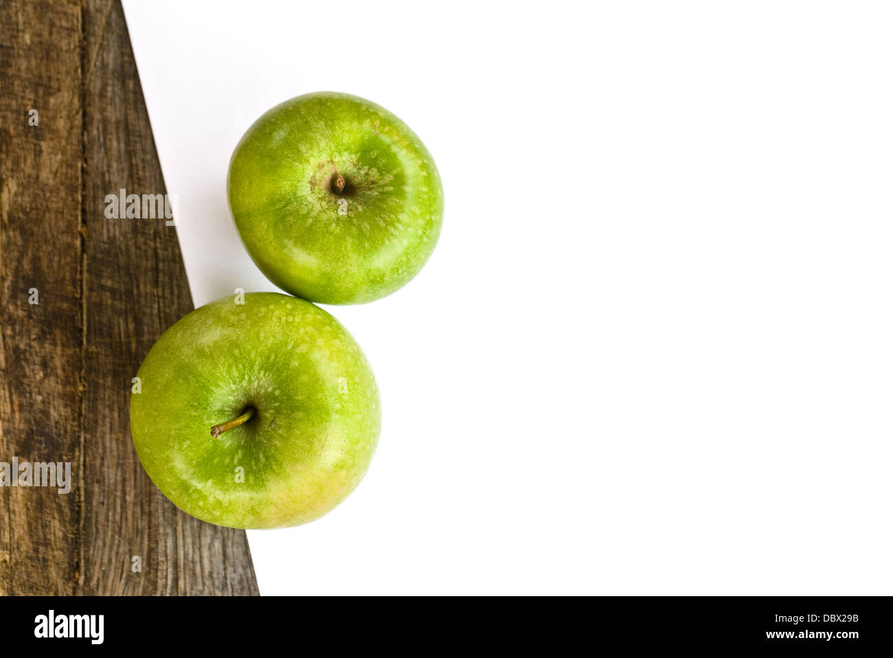 La pomme verte et le livre blanc sur le vieux bois, table en bois obsolète la texture. Banque D'Images