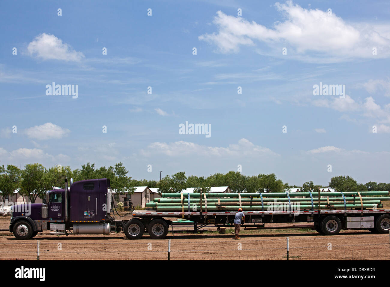 Un travailleur obtient une charge de tuyau sur son camion pour une utilisation dans l'Eagle Ford Shale, une zone d'intense production pétrolière et gazière. Banque D'Images